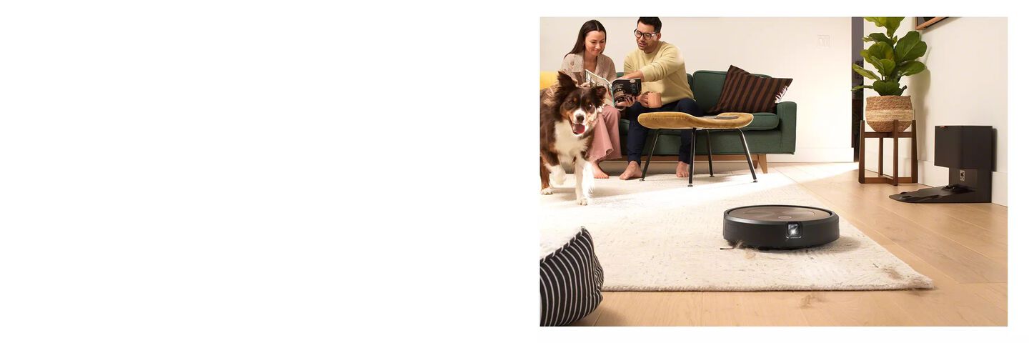 l&rsquo;aspirateur Roomba&reg; aspire des poils de chien, un couple et un chien sont &agrave; l&rsquo;arri&egrave;re-plan